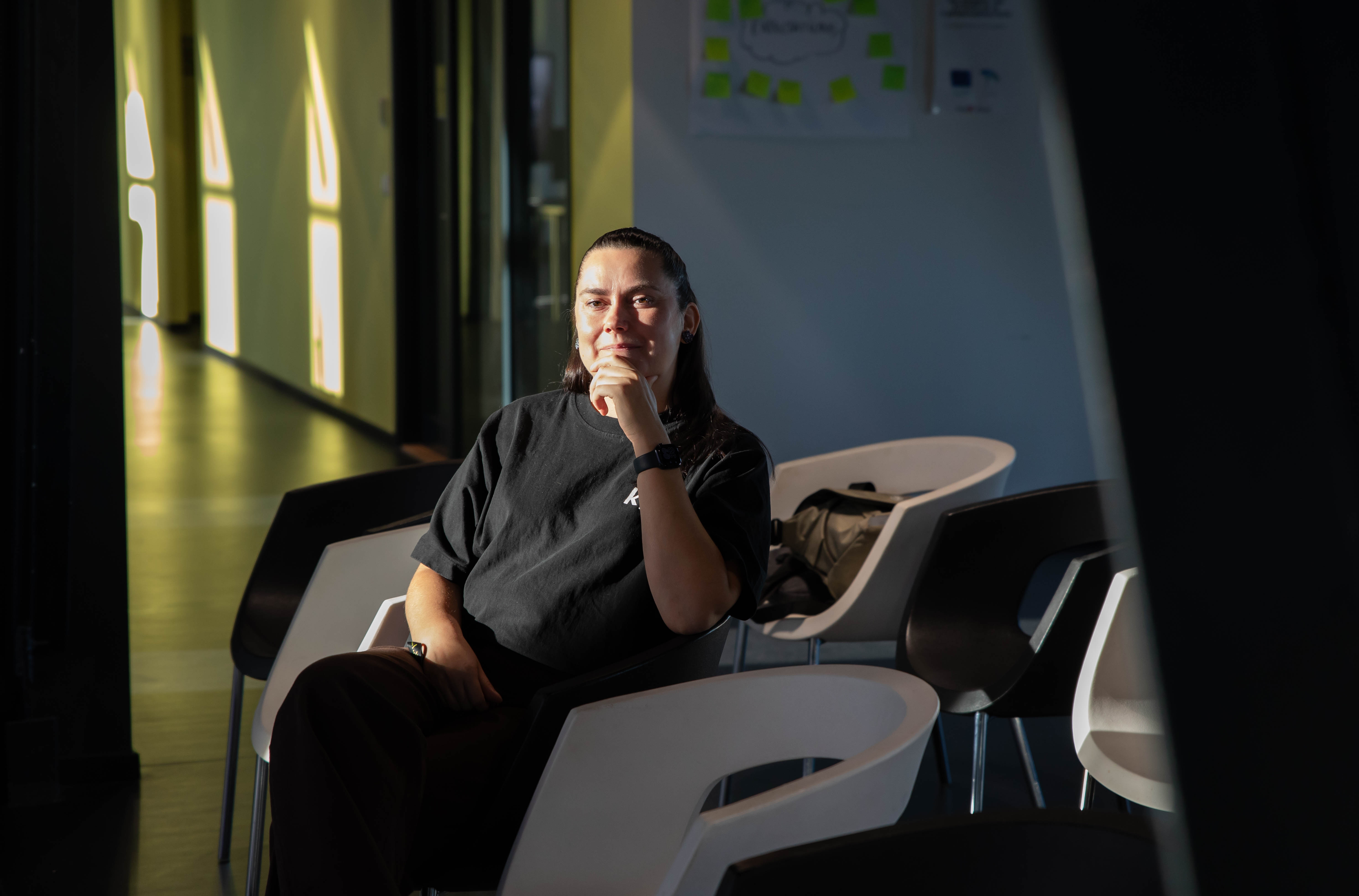 Kätlin Merisalu sitting while looking at presentations in sunshine kood Empower Garage48